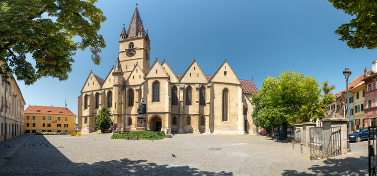 View of the Evangelical Cathedral of Sibiu with its Gothic architecture clock tower and cobblestone square in Sibiu Sibiu Romania. View of the Evangelical Cathedral of Sibiu with its Gothic architecture clock tower and cobblestone square in Sibiu Sibiu Romania.