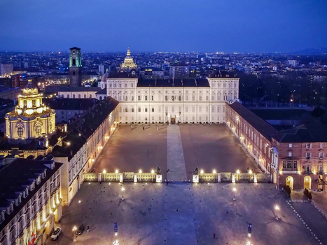 Aerial view of the Royal Palace of Turin and Piazza Castello illuminated at twilight with city lights in the background Turin Piedmont Italy.