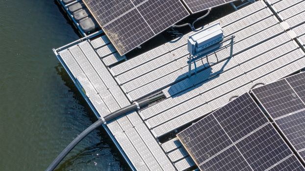 Aerial view of floating solar panels on a platform with metal walkways and electrical cables on the water surface in Zwolle Overijssel Netherlands. Aerial view of floating solar panels on a platform with metal walkways and electrical cables on the water surface in Zwolle Overijssel Netherlands.
