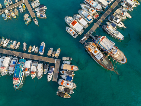 Aerial view of boats clustered tightly in the harbor their hues contrasting with the turquoise waters Mgarr Harbour Gozo Malta. Aerial view of boats clustered tightly in the harbor their hues contrasting with the turquoise waters Mgarr Harbour Gozo Malta.