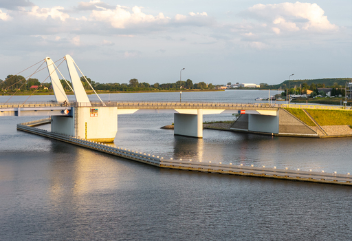 Aerial view of the Sobieszewo Bridge spanning the Martwa Wisla river with its modern drawbridge structure illuminated by golden hour light in Gdansk Pomeranian Voivodeship Poland.