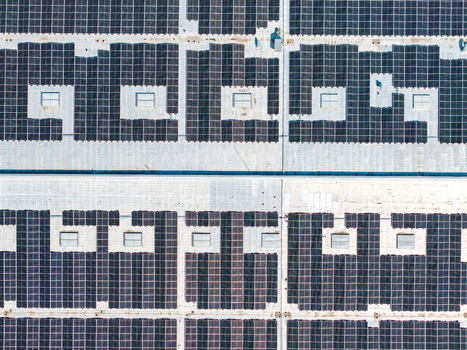 Aerial view of the extensive solar panel array installed on the large industrial rooftop of the Glas Trosch Alsace SAS facility in Hombourg Grand Est France.