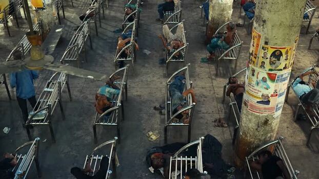 View of people sleeping on benches in a station Bangladesh.