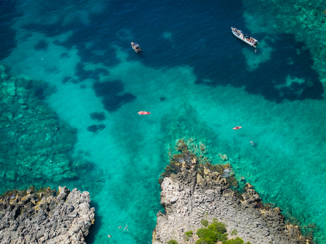 Aerial view of Aquarium Beach with turquoise crystal clear water rocky cliffs small boats and people swimming in Jala Vlore County Albania. Aerial view of Aquarium Beach with turquoise crystal clear water rocky cliffs small boats and people swimming in Jala Vlore County Albania.