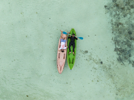 Aerial view of two people relaxing on kayaks in the crystal clear turquoise waters surrounding Menjangan Kecil Island Karimunjawa Central Java Indonesia.