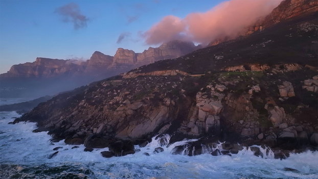 Aerial view of the Twelve Apostles mountain range with crashing waves against rocky cliffs under a sunset sky Cape Town Western Cape South Africa. Aerial view of the Twelve Apostles mountain range with crashing waves against rocky cliffs under a sunset sky Cape Town Western Cape South Africa.