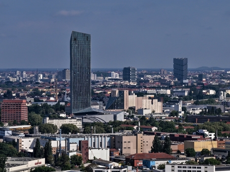 Aerial view of the Estrel Tower skyscraper rising above the urban skyline with industrial buildings and residential blocks under a clear blue sky in Berlin Berlin Germany. Aerial view of the Estrel Tower skyscraper rising above the urban skyline with industrial buildings and residential blocks under a clear blue sky in Berlin Berlin Germany.