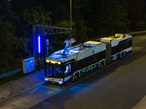 Krakow Poland 03 July 2026 Aerial view of an electric bus charging at a station at night illuminated by blue charging lights and street lighting.