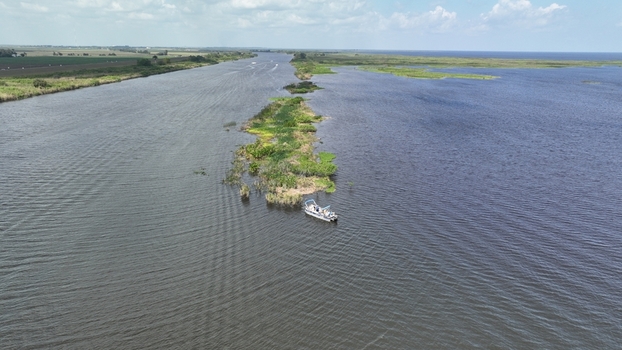 Aerial view of a boat sailing by a small island in the middle of a river Lake Okeechobee Florida United States.