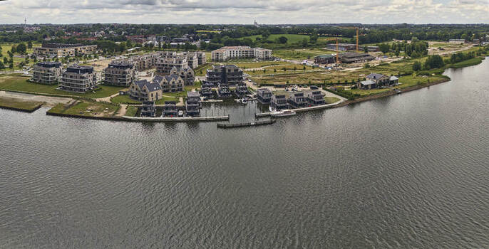 Schleswig Schleswig Holstein Germany 01 July 2026 Aerial view of the Quatier Schlei Leben redevelopment featuring modern residential buildings and floating houses in the harbor.