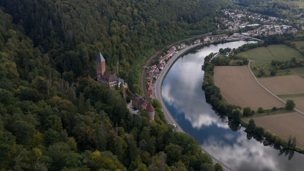 Aerial view of Zwingenberg Castle on a forested hillside overlooking the Neckar river with a railway line and fields in Zwingenberg Baden Wurttemberg Germany. Aerial view of Zwingenberg Castle on a forested hillside overlooking the Neckar river with a railway line and fields in Zwingenberg Baden Wurttemberg Germany.