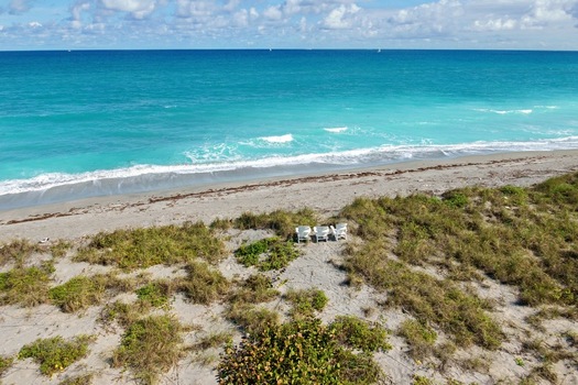 Aerial view of the beach with the turquoise water meeting the sandy shore Jupiter Island Florida United States.