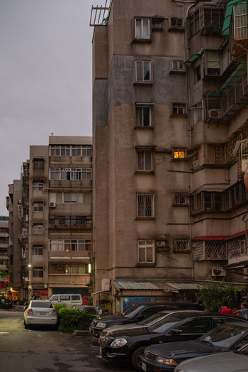 View of residential apartment buildings with parked cars on a street in the evening in Zhongzheng District Taipei City Taiwan. View of residential apartment buildings with parked cars on a street in the evening in Zhongzheng District Taipei City Taiwan.