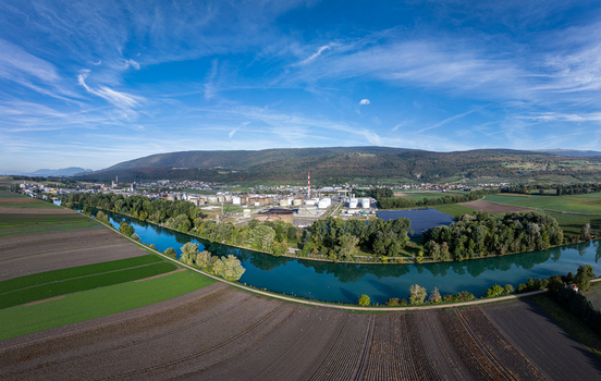 Aerial view of the Cressier Refinery situated along the river with surrounding agricultural fields and hills in Cornaux Neuchatel Switzerland. Aerial view of the Cressier Refinery situated along the river with surrounding agricultural fields and hills in Cornaux Neuchatel Switzerland.