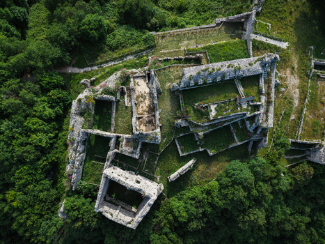 Aerial view of the historic stone ruins of the Castello di Mercato San Severino surrounded by dense green forest and vegetation in Mercato San Severino Campania Italy.