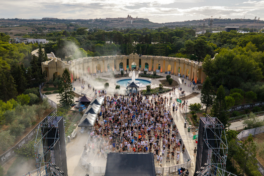 Attard Northern Region Malta 20 September 2026 Aerial view of a music festival at Park Nazzjonali Ta Qali with a large crowd central fountain and Mdina in the background. Attard Northern Region Malta 20 September 2026 Aerial view of a music festival at Park Nazzjonali Ta Qali with a large crowd central fountain and Mdina in the background.