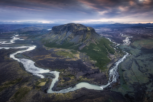 Aerial view of the waterfall Thjofafoss and the winding Thjorsa river flowing around the volcanic mountain Burfell in the rugged landscape of Rangarthing ytra Iceland. Aerial view of the waterfall Thjofafoss and the winding Thjorsa river flowing around the volcanic mountain Burfell in the rugged landscape of Rangarthing ytra Iceland.