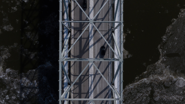 Aerial view of a steel truss bridge crossing a river filled with ice floes and cars driving on the road Cincinnati Ohio United States. Aerial view of a steel truss bridge crossing a river filled with ice floes and cars driving on the road Cincinnati Ohio United States.