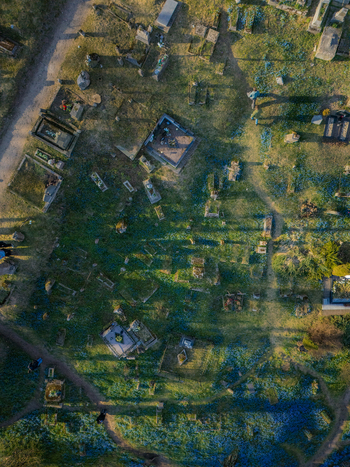 Aerial view of the historic Bernardine Cemetery with old gravestones winding paths and blue flowers under golden hour light in Vilnius Vilniaus apskritis Lithuania. Aerial view of the historic Bernardine Cemetery with old gravestones winding paths and blue flowers under golden hour light in Vilnius Vilniaus apskritis Lithuania.