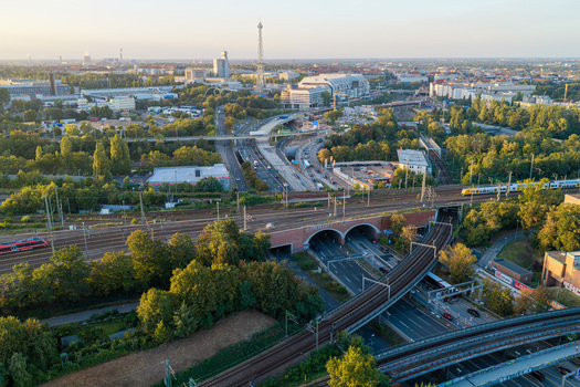 Aerial view of the ICC Berlin featuring its distinct brutalist architecture surrounded by railway tracks urban roads and lush green trees in Berlin Berlin Germany. Aerial view of the ICC Berlin featuring its distinct brutalist architecture surrounded by railway tracks urban roads and lush green trees in Berlin Berlin Germany.