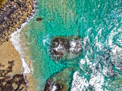 Aerial view of Cudgen Headland South Head featuring rocky formations turquoise ocean water and crashing waves along the sandy coastline in Kingscliff New South Wales Australia. Aerial view of Cudgen Headland South Head featuring rocky formations turquoise ocean water and crashing waves along the sandy coastline in Kingscliff New South Wales Australia.