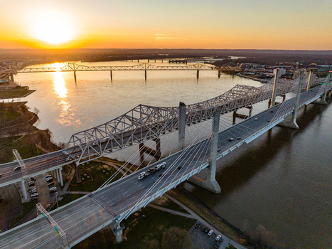 Aerial view of the Abraham Lincoln Bridge and Kennedy Memorial Bridge spanning the Ohio River during a vibrant sunset with traffic Louisville Kentucky United States. Aerial view of the Abraham Lincoln Bridge and Kennedy Memorial Bridge spanning the Ohio River during a vibrant sunset with traffic Louisville Kentucky United States.