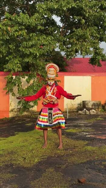 View of a Theyyam performer in traditional costume in Kochi India. View of a Theyyam performer in traditional costume in Kochi India.
