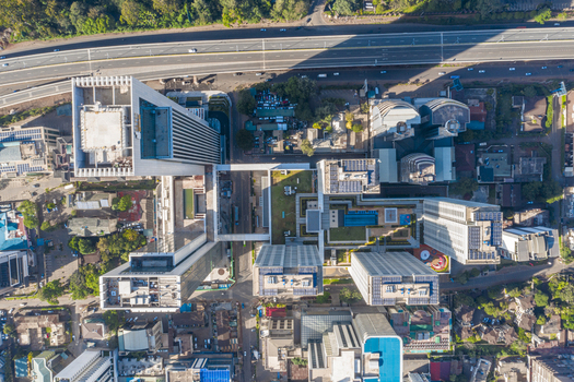 Aerial view of modern skyscrapers and urban architecture in the Westlands district featuring rooftop terraces solar panels and a busy highway in Nairobi Nairobi County Kenya. Aerial view of modern skyscrapers and urban architecture in the Westlands district featuring rooftop terraces solar panels and a busy highway in Nairobi Nairobi County Kenya.