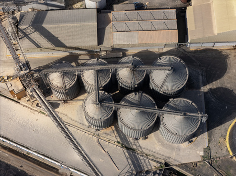 Aerial view of industrial grain silos in an industrial facility with metal structures and paved ground in Bajos de Haina San Cristobal Provinc Dominican Republic.