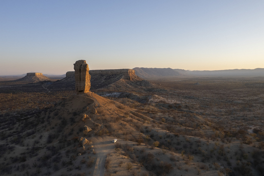 Aerial view of the majestic rock formation the finger of God stands tall amidst the arid landscape its warm hues contrasting with the cool blue sky Khorixas Namibia. Aerial view of the majestic rock formation the finger of God stands tall amidst the arid landscape its warm hues contrasting with the cool blue sky Khorixas Namibia.