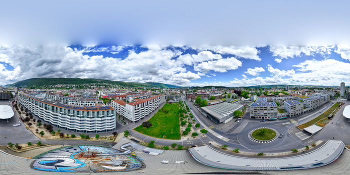 Aerial view of modern residential complexes green urban spaces and a roundabout under a dramatic cloudy sky in Biel Bienne Canton of Bern Switzerland. Aerial view of modern residential complexes green urban spaces and a roundabout under a dramatic cloudy sky in Biel Bienne Canton of Bern Switzerland.