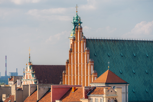 View of St. John s Archcathedral with its distinctive red brick facade and green copper roof surrounded by historic rooftops in the Old Town Warsaw Masovian Voivodeship Poland. View of St. John s Archcathedral with its distinctive red brick facade and green copper roof surrounded by historic rooftops in the Old Town Warsaw Masovian Voivodeship Poland.