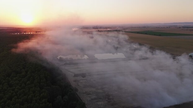 Aerial view of smoke over fields at sunset Serbia.