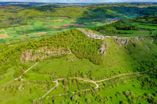 Aerial view of the Walberla hill with its distinctive rocky cliffs lush green meadows and the chapel on the summit plateau Kirchehrenbach Bavaria Germany. Aerial view of the Walberla hill with its distinctive rocky cliffs lush green meadows and the chapel on the summit plateau Kirchehrenbach Bavaria Germany.