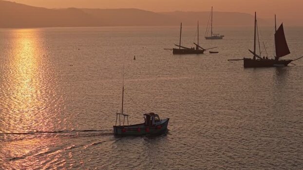 Aerial view of fishing boats on the sea at sunset United Kingdom. Aerial view of fishing boats on the sea at sunset United Kingdom.