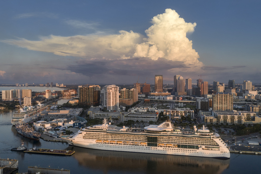 Tampa Florida United States 04 July 2026 Aerial view of Tampa Cruise Terminal 6 with a large cruise ship docked downtown skyline and dramatic sunset clouds.