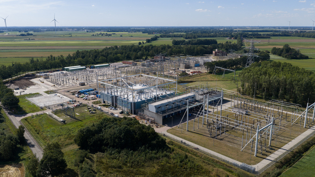 Aerial view of the Hoogspanningsstation Meeden high voltage substation featuring electrical infrastructure and power lines surrounded by green fields in Meeden Groningen Netherlands.