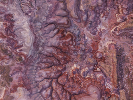 Aerial view of the Bentonite Hills showcasing unique vibrant and layered clay formations with striking red purple and grey hues in the desert landscape of Hanksville Utah United States.
