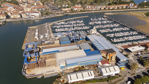 Aerial view of the marina and industrial harbor facilities with numerous sailboats docked in the water and buildings along the waterfront in Zumaia Basque Country Spain.