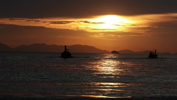View of longtail boats in Ao Nang at sunset Thailand.