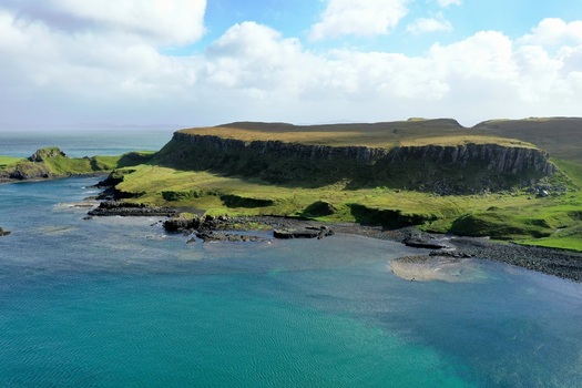 Aerial view of The Brother s Point featuring rugged cliffs grassy headlands and turquoise coastal waters under a bright sky in Culnacnoc Scotland United Kingdom. Aerial view of The Brother s Point featuring rugged cliffs grassy headlands and turquoise coastal waters under a bright sky in Culnacnoc Scotland United Kingdom.
