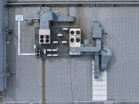 Aerial view of industrial rooftop with HVAC units and ventilation ducts on a corrugated metal surface in Melbourne VIC Australia.