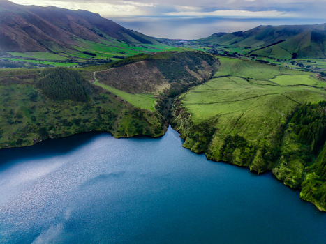 Aerial view of the striking contrast between the deep blue waters of Lake Comprida and the surrounding verdant hills Flores Azores Portugal.