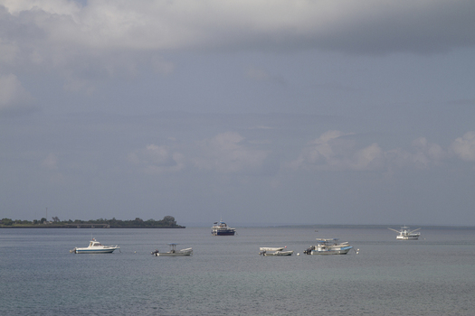 View of small boats anchored in the calm ocean waters near the shoreline of Tiwi Beach Tiwi Wilaya ya Kwale Kenya. View of small boats anchored in the calm ocean waters near the shoreline of Tiwi Beach Tiwi Wilaya ya Kwale Kenya.