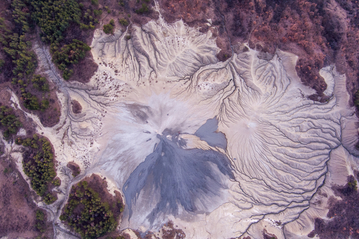 Aerial view of the Mud Volcanoes of Paclele Mari showing intricate grey mud flows and patterns in the landscape of Paclele Buzau County Romania.