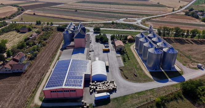 Aerial view of storage silo Bavaniste with metal grain bins a warehouse featuring solar panels on its roof and surrounding agricultural fields in Bavaniste Vojvodina Serbia.
