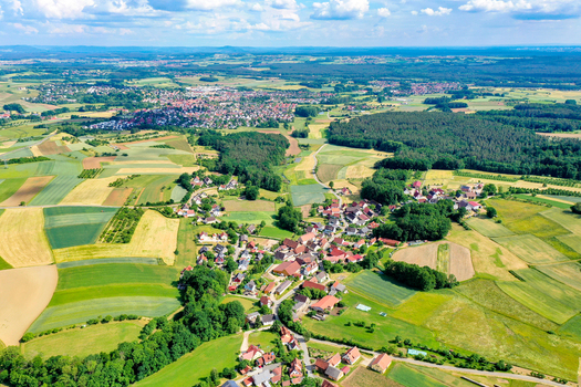 Aerial view of the historic town of Neunkirchen am Brand nestled among lush green fields and dense forests under a bright blue sky Neunkirchen am Brand Bavaria Germany. Aerial view of the historic town of Neunkirchen am Brand nestled among lush green fields and dense forests under a bright blue sky Neunkirchen am Brand Bavaria Germany.