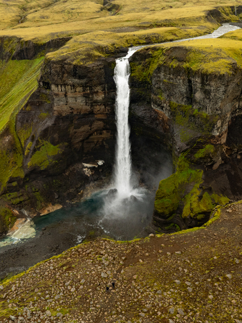 Aerial view of the majestic Haifoss waterfall plunging into a deep canyon surrounded by mossy green cliffs and rugged volcanic terrain in Skeida og Gnupverjah Iceland. Aerial view of the majestic Haifoss waterfall plunging into a deep canyon surrounded by mossy green cliffs and rugged volcanic terrain in Skeida og Gnupverjah Iceland.
