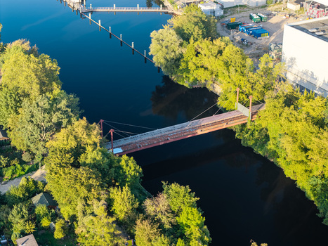 Aerial view of the pipeline bridge at the Combined Heat and Power Plant Lichterfelde crossing the Teltow Canal surrounded by lush green trees in Berlin Berlin Germany. Aerial view of the pipeline bridge at the Combined Heat and Power Plant Lichterfelde crossing the Teltow Canal surrounded by lush green trees in Berlin Berlin Germany.