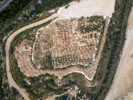 Aerial view of a quarry excavation site with terraced land exposed soil and surrounding dirt roads in Teulada Valencian Community Spain.